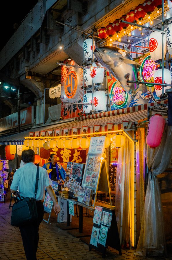 Tonno di plastica a grandezza naturale sopra l’ingresso di un izakaya tra decine di lanterne accese, Ueno, Tokyo