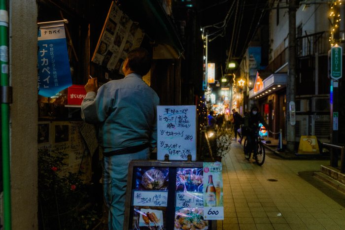 Tokyo uomo porta izakaya, fotografia di viaggio e street photography in Giappone