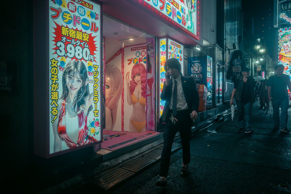 Uomo in giacca al telefono davanti alle insegne illuminate, Kabukichō, Tokyo