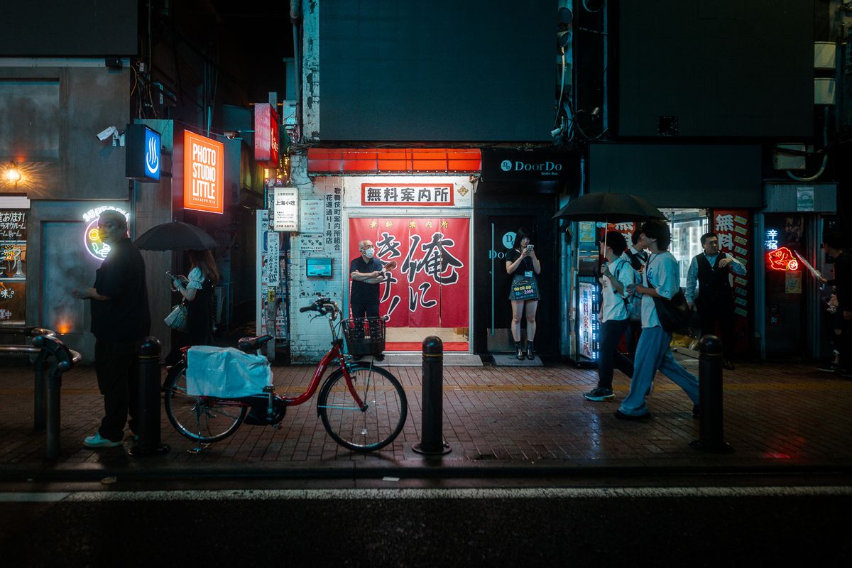 Bicicletta rossa parcheggiata davanti a una vetrina illuminata, Kabukichō, Tokyo