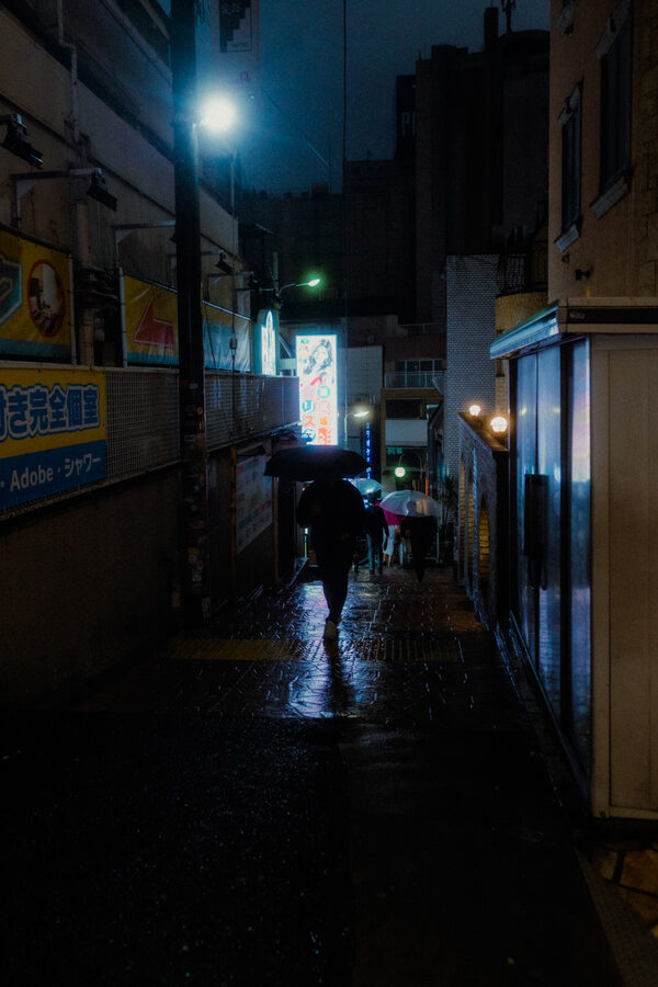 Figura cammina in un vicolo quasi buio, Tokyo
