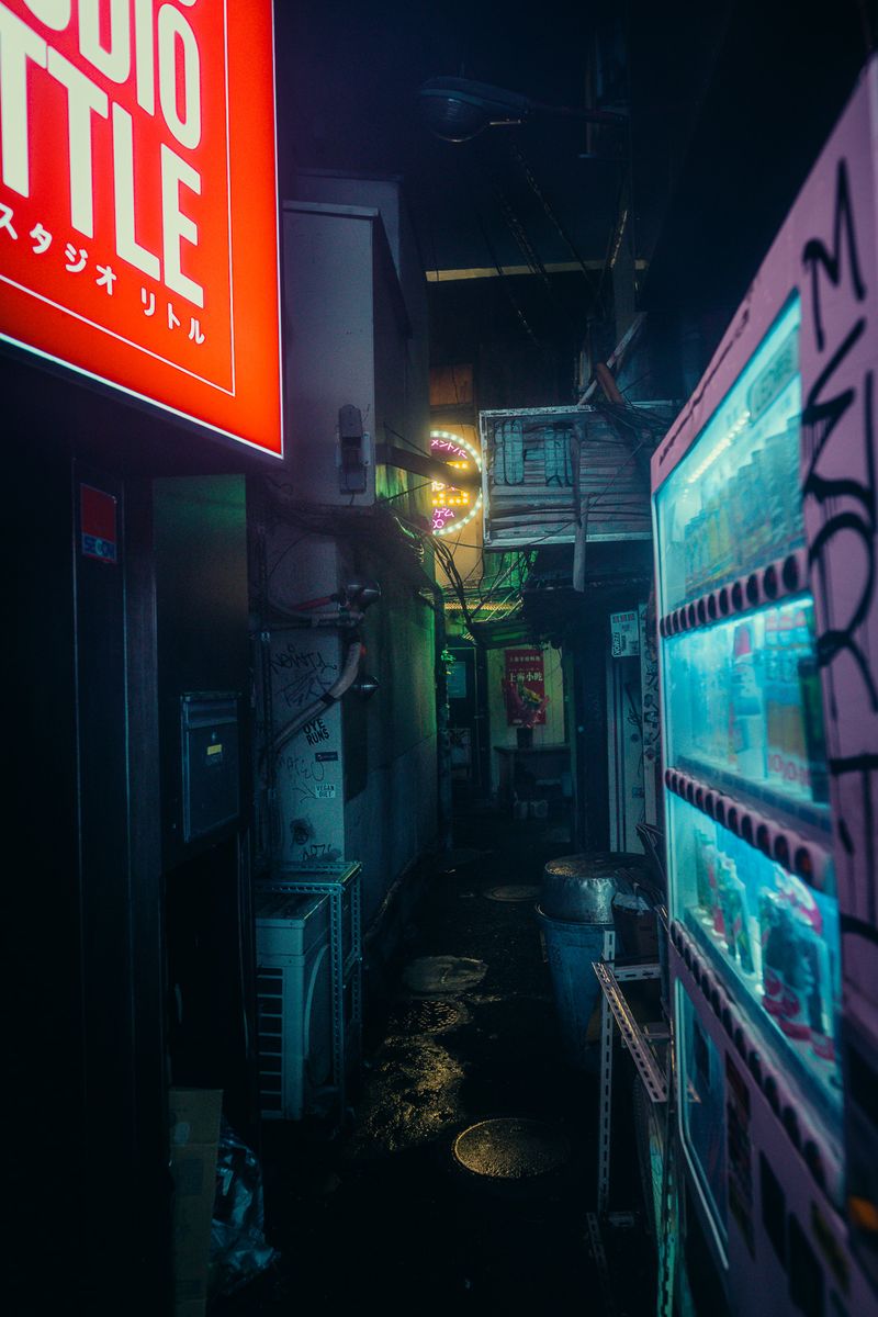 Vicolo stretto tra un’insegna rossa e un distributore automatico illuminato, Kabukichō, Tokyo
