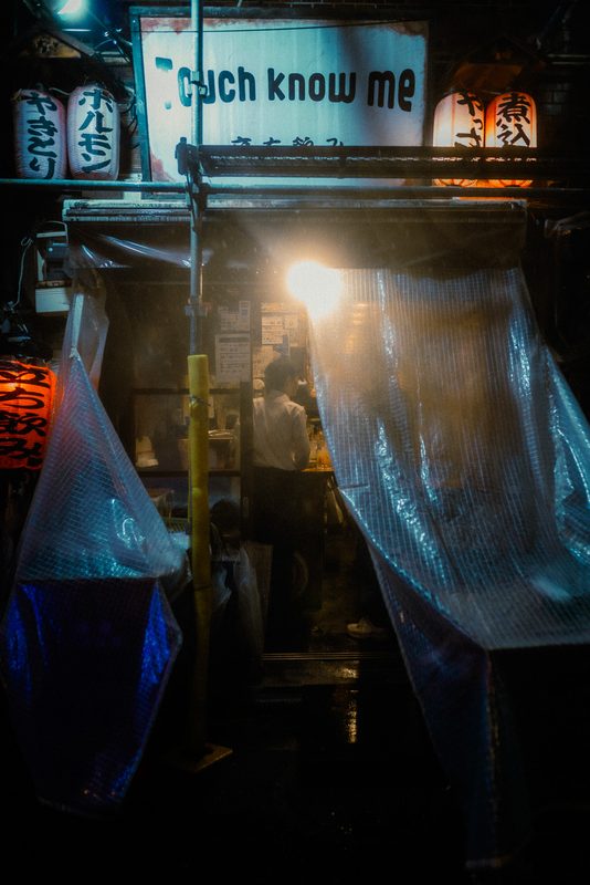 Interno di un yatai illuminato con teli di plastica e lanterne, insegna Touch know me, notte di pioggia, Tokyo